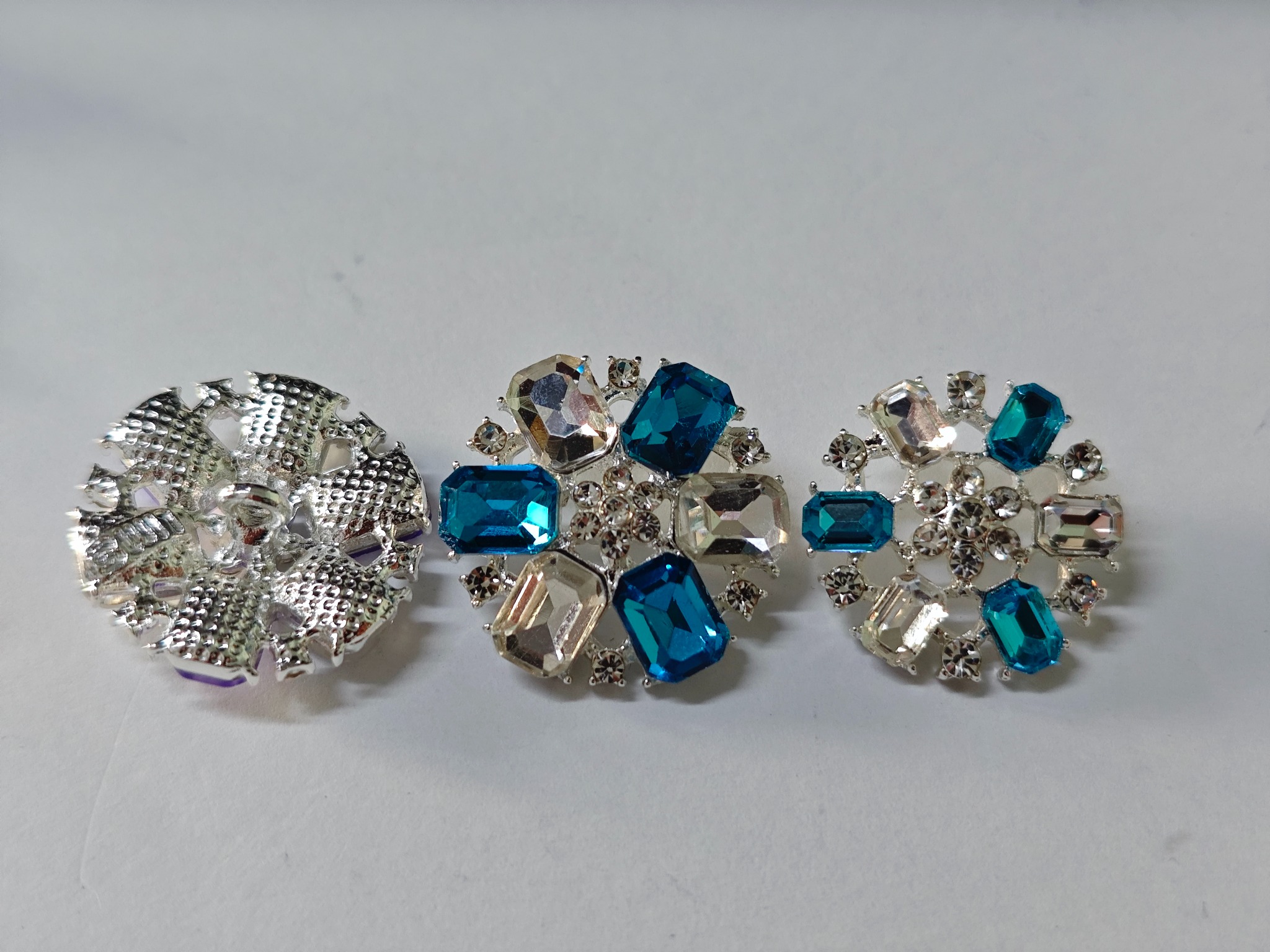 Silver-tone floral garment buttons with clear and blue crystal-effect details