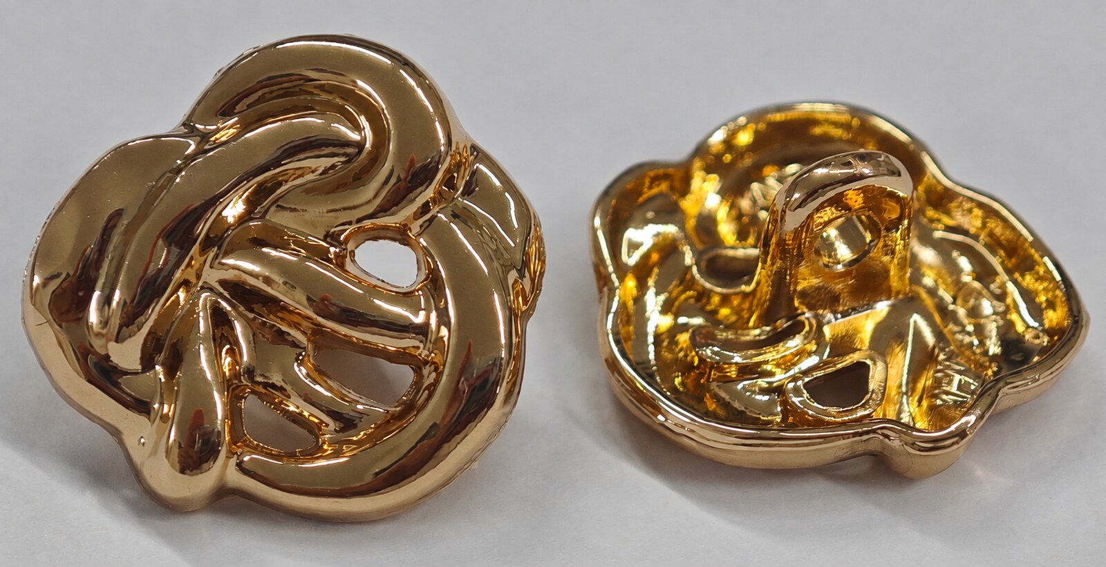 Gold-tone openwork floral garment button shown from the front and reverse