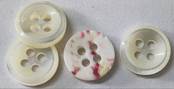 Natural shell garment buttons showing variations in luster and color