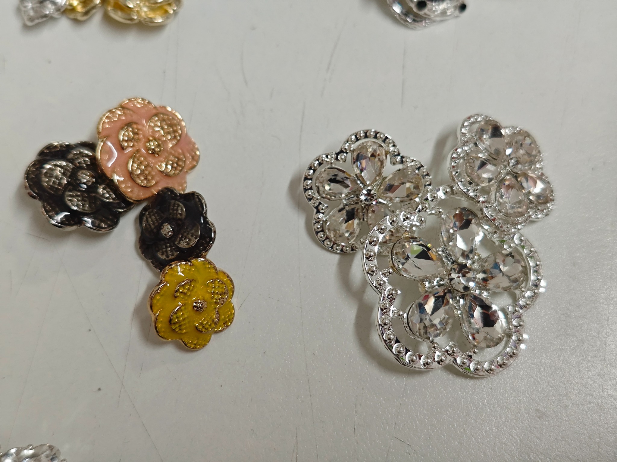 A selection of colorful floral and crystal-effect decorative garment buttons