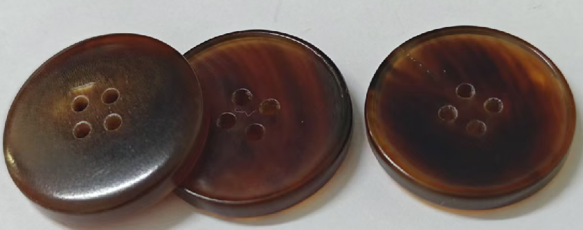Natural horn garment buttons showing variations in color and grain