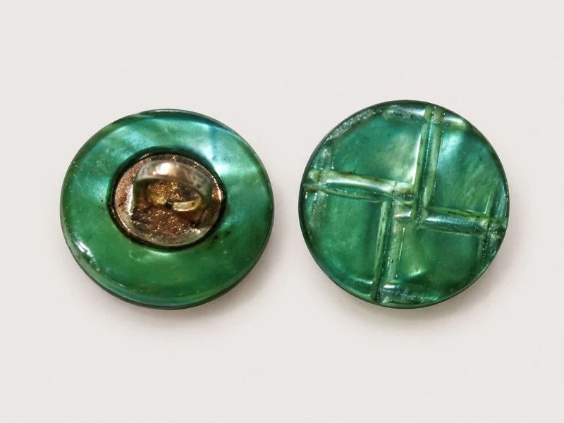 Combination shell button showing a geometric face and a metal shank on the reverse.