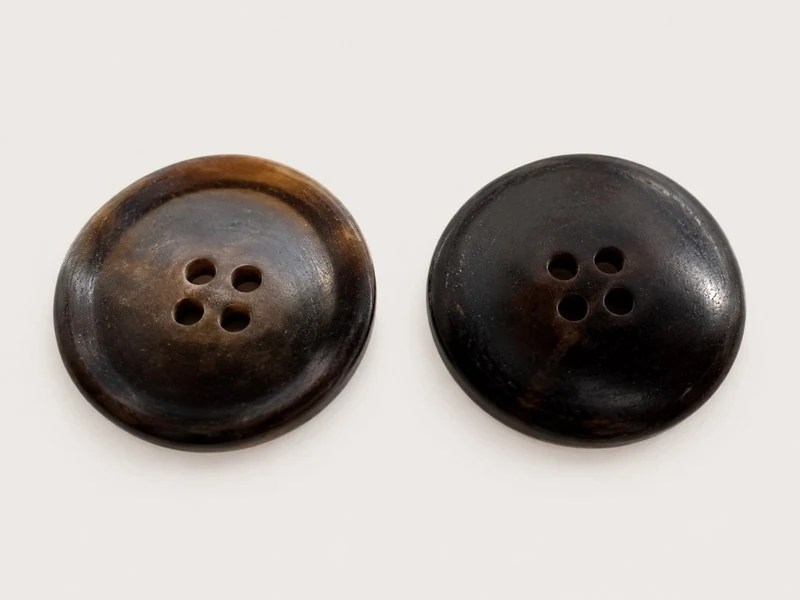 KN2105002 dark brown round horn buttons shown from the front and reverse.
