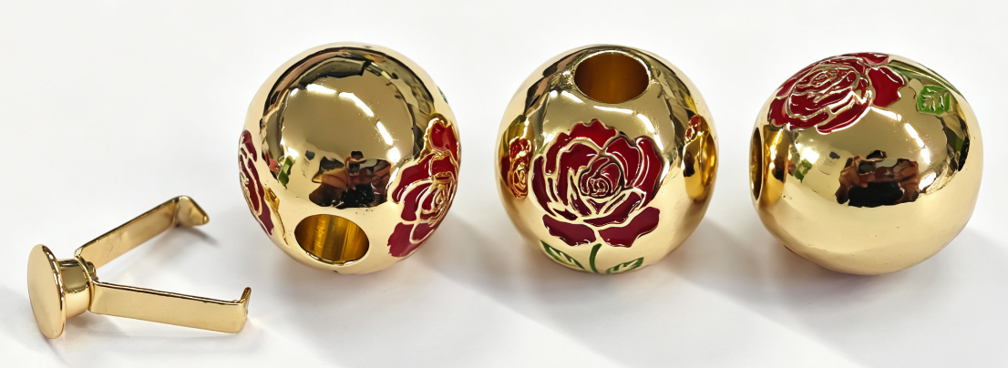 Gold-tone spherical cord-end samples with red roses, green leaves and a separate copper clip